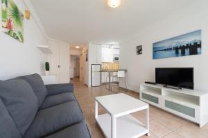 ein Wohnzimmer mit einem Sofa und einem TV in der Unterkunft Las Adelfas South Beach 2 By CanariasGetaway in San Bartolomé de Tirajana