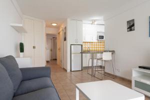 ein Wohnzimmer mit einem Sofa und einer Küche in der Unterkunft Las Adelfas South Beach 2 By CanariasGetaway in San Bartolomé de Tirajana