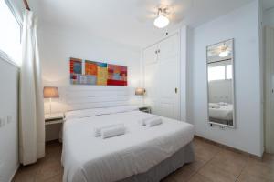 ein weißes Schlafzimmer mit 2 Betten und einem Fenster in der Unterkunft Las Adelfas South Beach 2 By CanariasGetaway in San Bartolomé de Tirajana