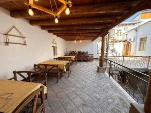 a restaurant with tables and chairs on a balcony at Sarrafon Guest House in Bukhara +29 photos