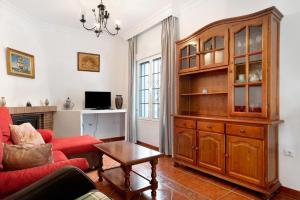 科尼爾－德拉弗龍特拉的住宿－Casa 4，客厅配有红色沙发和大型木制橱柜