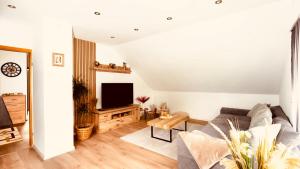 哈姆3,5-Zimmer inkl Arbeitsplatz, WLAN & free Netflix, Amazon-Free Parken vollausgestattete Wohnung, 24h Check In的客厅里有一张沙发和一台电视