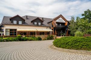 a large house with a brick driveway in front of it at Hotel Cztery Pory Roku in Głogów Małopolski