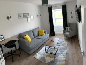 ein Wohnzimmer mit einem Sofa und einem Tisch in der Unterkunft Pass the Keys River View Snowdonia Town Apartment in Bethesda