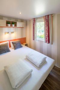 2 weiße Betten in einem Zimmer mit Fenster in der Unterkunft Camping Marvilla Parks Friese Meren - Roan in Wijckel