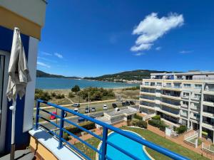 un balcón con vistas a un edificio y a un cuerpo de agua en Apartamento con vistas al mar Urb Puerto Azul B5, en Cedeira