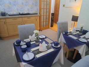 two tables with blue and white dishes on them at No 27 in Inverness
