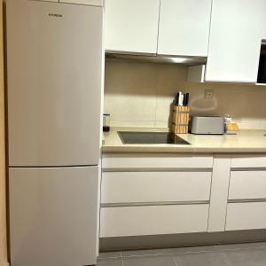 コスタ・バジェーナにあるCosta Ballena Mar Abiertoの白いキャビネットと冷蔵庫のあるキッチン +7枚の写真