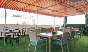 um pátio com mesas e cadeiras sob uma tenda em FabHotel Prime Finesse em Kharadi