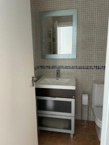 y baño con lavabo y espejo. en Apartamento con vistas al mar Urb Puerto Azul B5, en Cedeira
