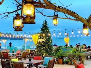 ein Weihnachtsbaum am Strand mit Tischen und Stühlen in der Unterkunft TMS QUY NHƠN - SUIN Luxury Aparment in Quy Nhon