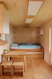 a room with a bed and a table in a cabin at Villa Ilex - Ein Massivholzhaus direkt am See in Görlitz