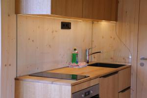 a kitchen counter with a sink and a faucet at Villa Ilex - Ein Massivholzhaus direkt am See in Görlitz