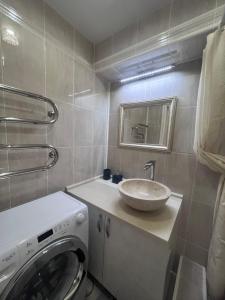 a bathroom with a sink and a washing machine at Уютная 3 комнатная квартира in Oral