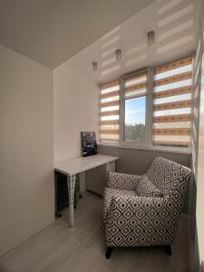Pokój z biurkiem, krzesłem i oknem w obiekcie Уютная 3 комнатная квартира w mieście Uralsk