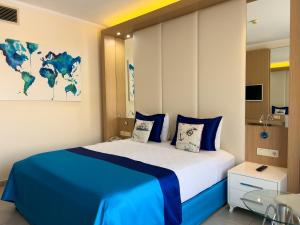 a bedroom with a large bed with a blue blanket at AQI Pegasos World in Side +98 photos