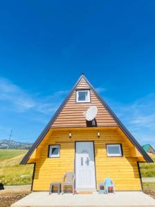 a house with a triangular roof with two chairs in front at Red Rock in Žabljak