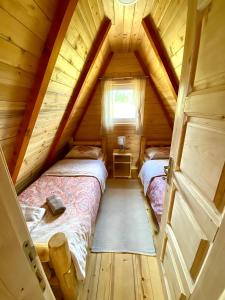 a attic bedroom with two beds in a log cabin at Red Rock in Žabljak
