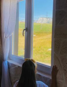 a girl looking out of a window at a field at Red Rock in Žabljak