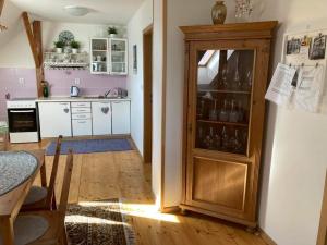a kitchen with a large wooden cabinet with glasses in it at Apartmány Lucie in Karlovice