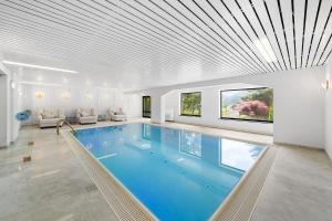 a swimming pool in a house with a white ceiling at Villa Chou Chou in Steinhaus am Semmering