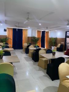 um restaurante com mesas, sofás e cadeiras em Posh Classic em Gurgaon