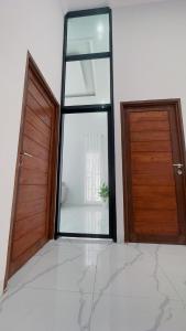 una stanza vuota con due porte e una finestra di Holiday Homestay Singkawang a Sedau