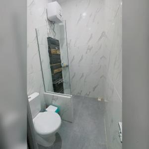 bagno bianco con servizi igienici e specchio di Holiday Homestay Singkawang a Sedau