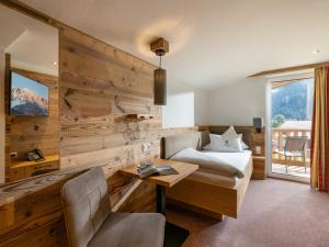 a hotel room with a bed and a desk at Alpenhof Hotel Garni Suprême in Zell am Ziller