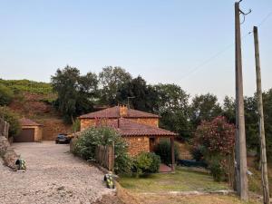 a brick house with a car parked in front of it at Casa da Touça in Celorico de Basto