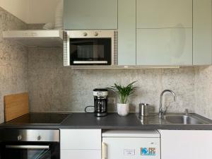 une cuisine avec des armoires blanches et un évier dans l'établissement New Vintage house with Netflix Füge és könyvtár, à Keszthely