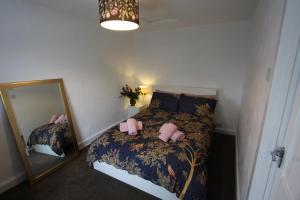 um pequeno quarto com uma cama e um espelho em Lymm Cottage em Lymm