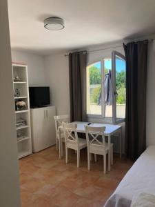 une chambre avec une table, des chaises et une fenêtre dans l'établissement Appartement dans bastide à Saint Rémy de Provence, à Saint-Rémy-de-Provence