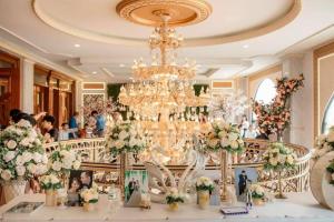 a room with a chandelier and a table with flowers at Tan An Palace in Hai Phong