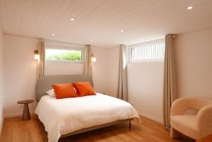 a bedroom with a bed with orange pillows and a window at Villa Jacqueline, la baie du Mont-Saint-Michel in Dragey