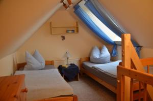two beds in a small room with a window at Am Kirchberg Ferienwohnungen in Kurort Oberwiesenthal