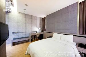 a hotel room with a bed and a desk at Military 75 Hotel in Taichung