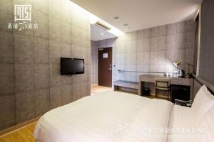 a hotel room with a bed and a kitchen at Military 75 Hotel in Taichung