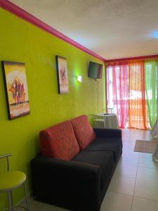- un salon avec un canapé et un mur vert dans l'établissement ARCOIRIS AL MAR, à San Marcos