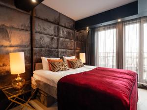 a bedroom with a large bed and a brick wall at Art Penthouse with Jacuzzi - Krakow Center in Kraków