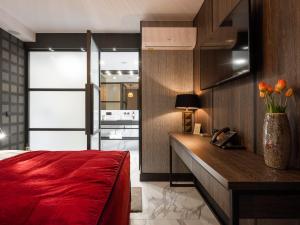 a bedroom with a red bed and a vase of flowers at Art Penthouse with Jacuzzi - Krakow Center in Kraków