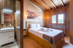 a bedroom with a large bed and a sink at Fernandes Guest house Yellow Bungalow in Ponte de Lima
