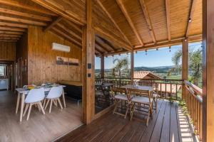 a wooden porch with tables and chairs on a deck at Fernandes Guest house Yellow Bungalow in Ponte de Lima