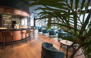 a restaurant with chairs and a bar and a plant at Crowne Plaza Berlin City Centre Ku'damm, an IHG Hotel in Berlin