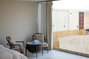 a bedroom with a bed and a table and chairs at Al-Rahal Desert Camp in Mesaieed