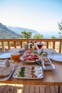 a table with plates of food and glasses of wine at Goat Bungalow and Camping in Faralya