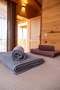 two towels sitting on top of a bed at Goat Bungalow and Camping in Faralya