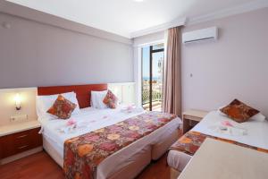 a hotel room with two beds and a window at Lara Dinc Hotel in Antalya