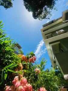 a building with pink flowers in front of a building at Sober 2bhk Pet Friendly Apartment with pool view in Marmagao