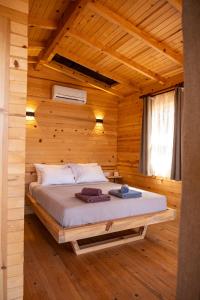1 dormitorio con 1 cama en una habitación de madera en Goat Bungalow and Camping, en Faralya